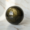 Gold Obsidian Kugel - Ein goldener Sternenhimmel in deiner Hand CrystalScents