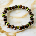 Elastisches Armband mit dunkelbraunen und grünen Holzperlen