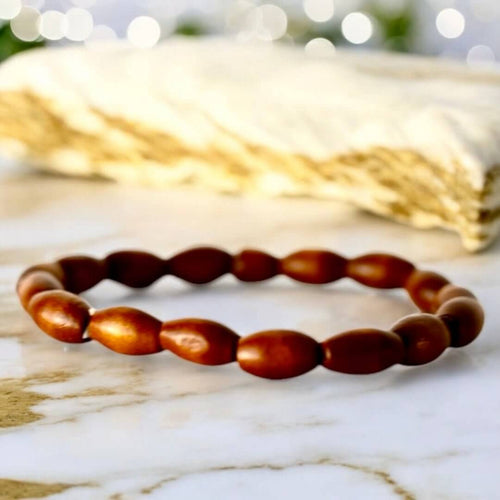 Elastisches Armband mit hellen länglichen Holzperlen