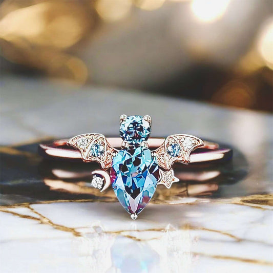 Roségoldener Ring mit funkelnder blauer „Fledermaus“